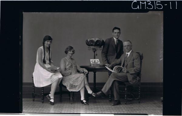 F/L Family Portrait of a man and woman seated, man holding a book, young woman and young man seated on table 'Murray'