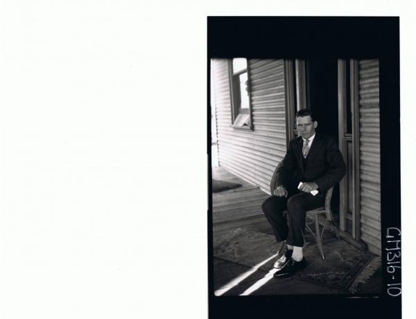 F/L Portrait of man wearing three piece suit, seated on verandah in front of house 'Moore'