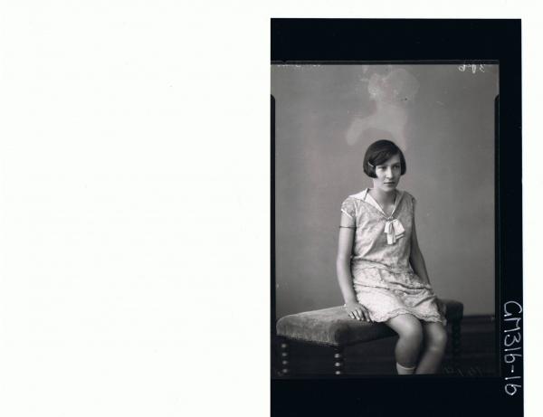 3/4 Portrait of girl seated wearing knee length embroidered dress 'McCahon'