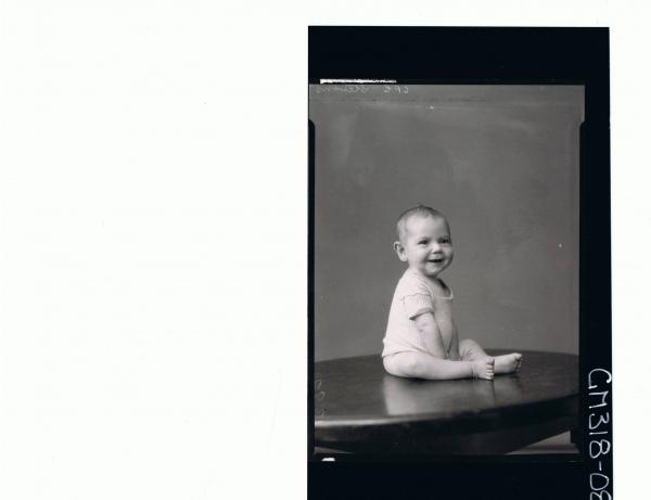 F/L Portrait of baby seated on table wearing vest; 'Stevens'