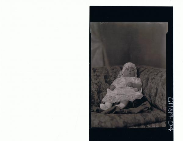 F/L Portrait of baby seated wearing lace christening gown and bonnet 'Summer'