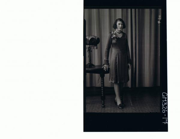 F/L Portrait of woman standing wearing knee length satin dress; 'Starr'