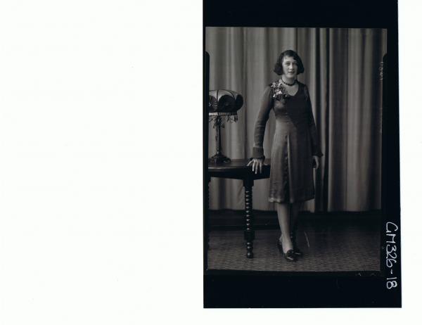 F/L Portrait of woman standing wearing knee length satin dress; 'Starr'