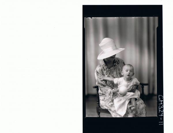 3/4 Portrait of woman seated wearing floral day dress and hat, holding baby and a ball; 'Stone'