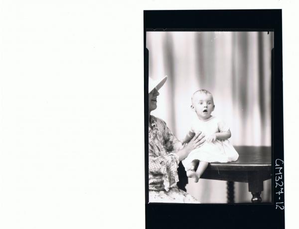 F/L Portrait of woman wearing floral dress, and baby seated on table; 'Stone'