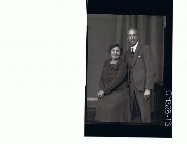 3/4 Portrait of man standing wearing 3 piece suit, woman seated, wearing 3/4 length dress; 'Sackville'