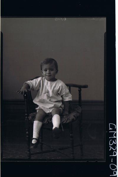 F/L Portrait of boy child seated wearing shorts, shirt; 'Basetrn'