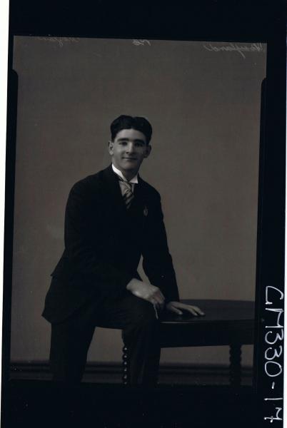 3/4 Portrait of man seated on table, wearing three piece suit; 'Moylan'