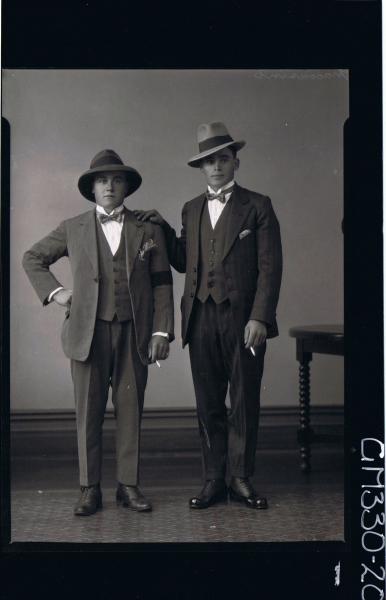 F/L Portrait of two young men standing, wearing three piece suits bow ties, hats, holding cigarettes; 'Maccasini'