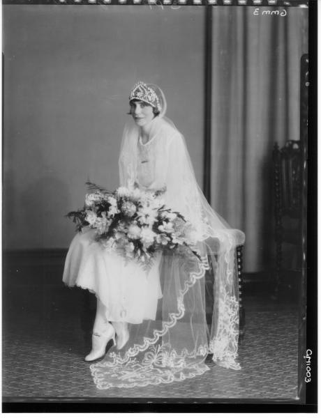 Jordan: portrait of seated bride wearing a tiara and long veil, holding a bouquet.