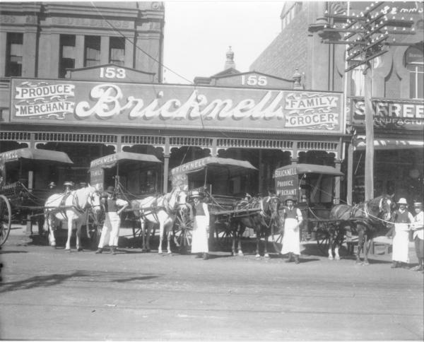 Bricknell store Hannan Street with delivery horses and carts and storemaen lined up outside.  Facade of the building reads:'153, 155' (referring to Hannan Street) 'Produce Merchant, Bricknell, Family Grocer'.  Business started by Frank W. Bricknell in Hannan Street 1897.