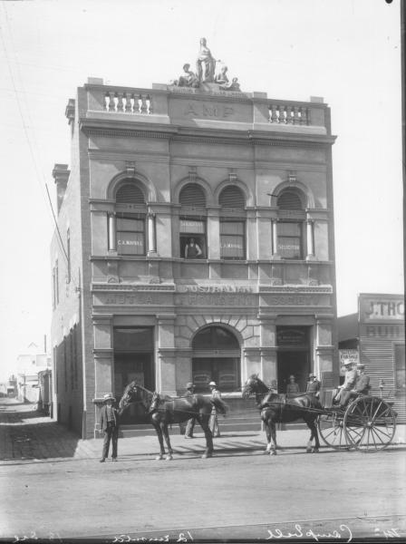 Sulkie and four horse team outside AMP building: man standing at window on second floor where 'solicitor C A Mayhall's  name is displayed. Men in street and two men in sulky. Mr Campbell