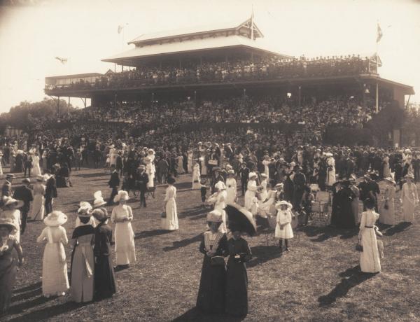 Large crowd at Kalgoorlie Racecourse, crowd on Grandstand in background.  1914