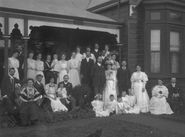 F/L portrait of large wedding group (32) including 7  children on verandah of house 'Craigross'. F.W. Daniels.