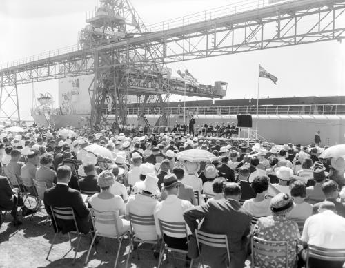 A seated crowd outside watching the Premier on stage B/W.