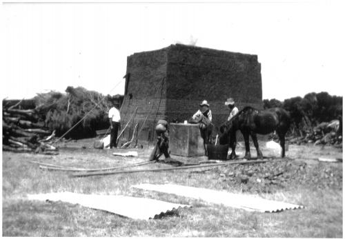 4 men and a horse working in front of a square brick Kiln about 14ft high B/W.