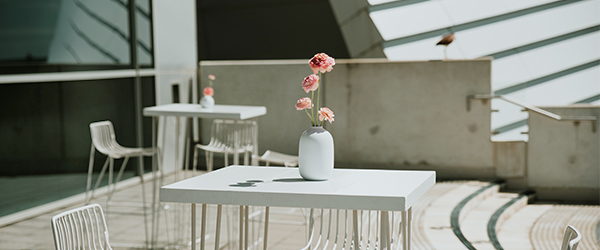 Image showing white table and chairs with flowers in an outdoor balcony setting