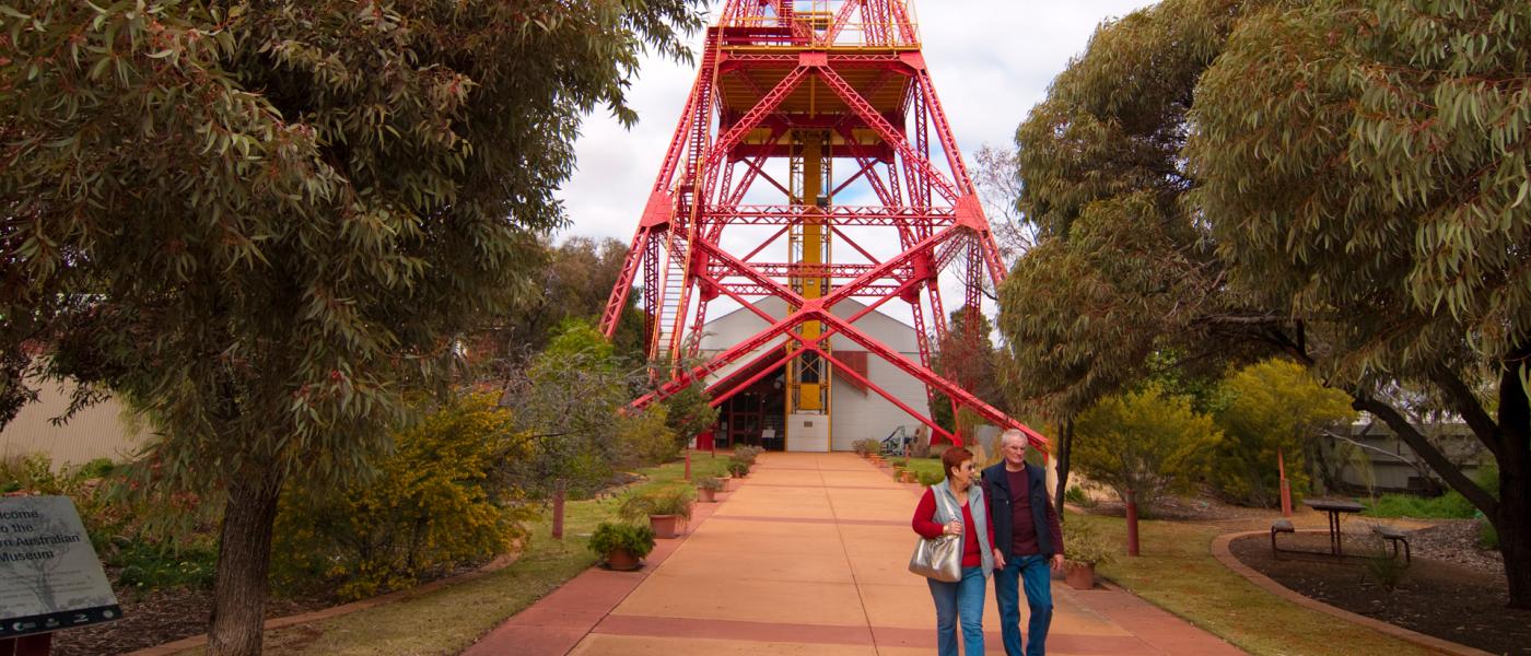 Two people walking in front of a museum