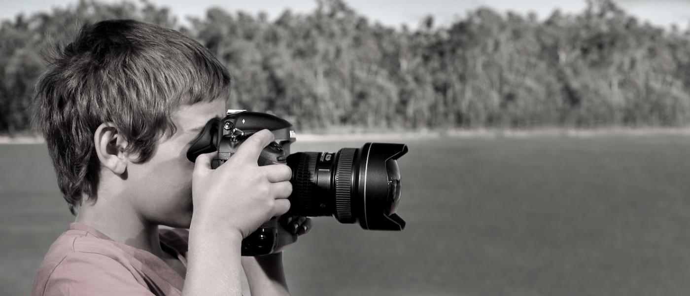 Child taking a photo outdoors.