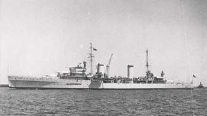 Port side view of white HMAS Sydney (II) viewed from a distance at sea