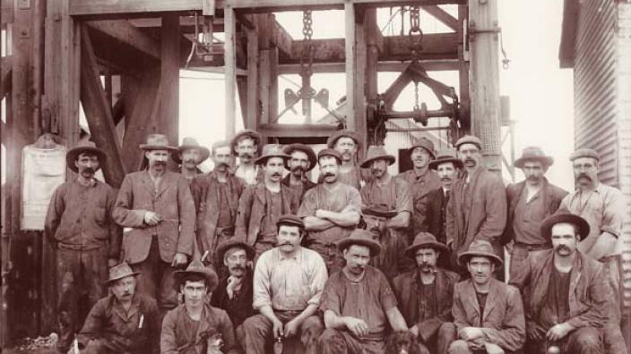 A group of miners waiting at the top of the mine shaft to start their shift.