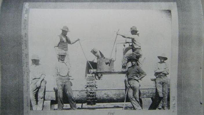 Men preparing lead jointing for pipe, c.1900s