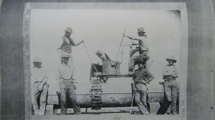 Men preparing lead jointing for pipe, c.1900s