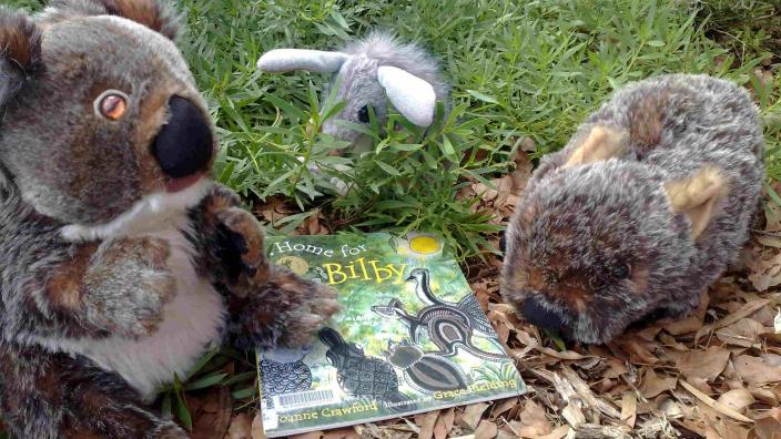 Three stuffed toys arranged in a garden