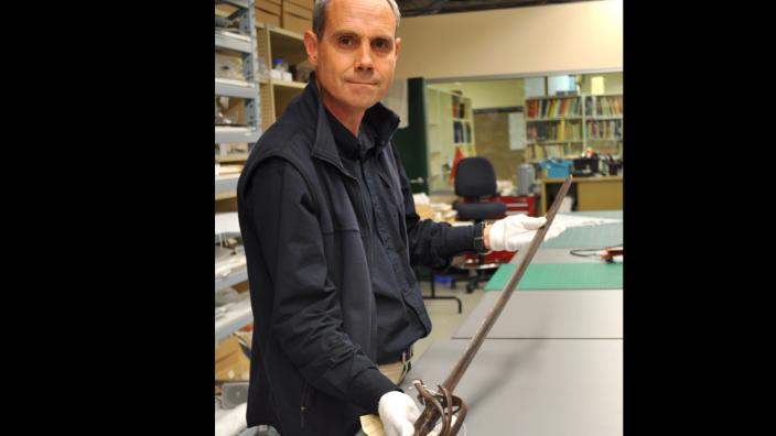 WA Museum curator Stephen Anstey with the sabre used by Henry Dyson Naylor