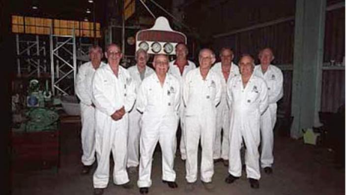 A group of mean wearing white, gathered in a huddle