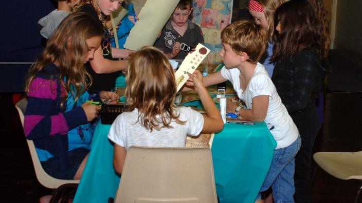 Kids doing craft around a table in the shipwrecks museum