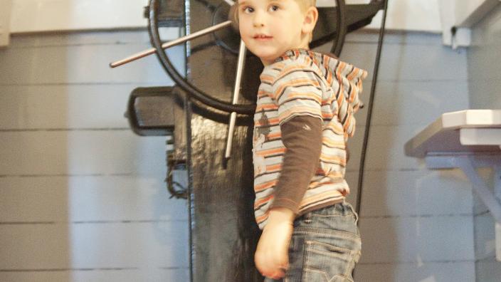 Kid at the ships wheel
