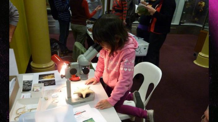 A child looking down a microscope