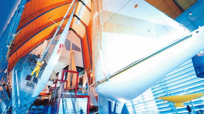 The hull of a large white boat suspended from a bright orange ceiling.