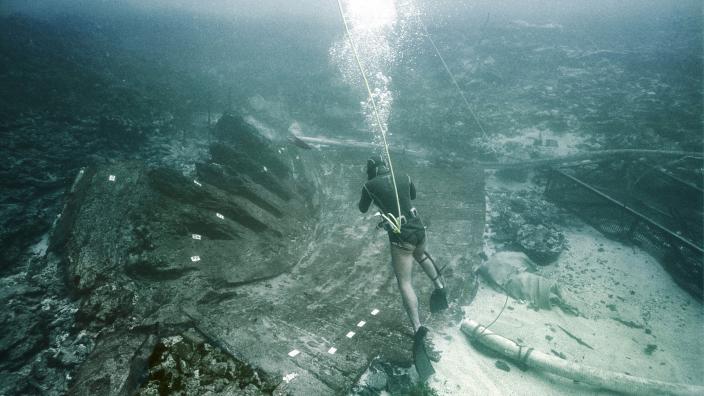 A diver exploring a shipwreck site underwater
