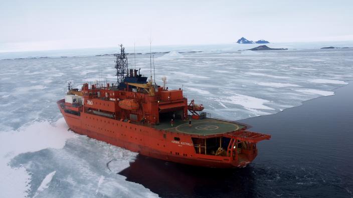 An icebreaker ship ploughing into an ice shelf