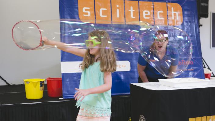 A child playing with a large bubble at Science Wonderland