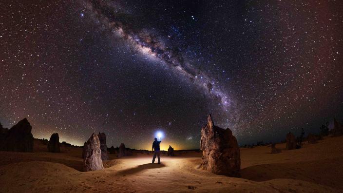 Man standing under night sky at Nambung National Park.