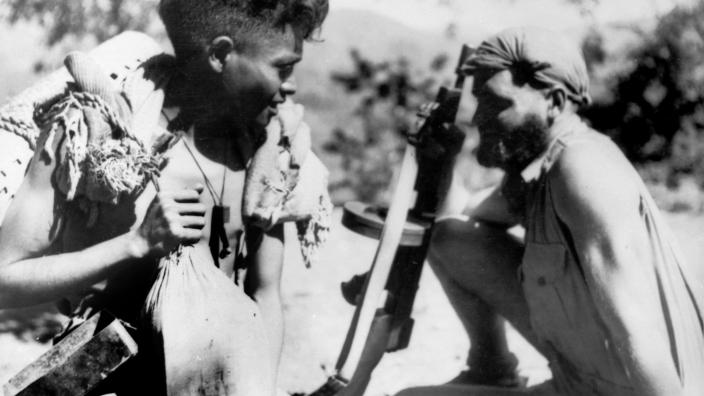 Australian soldier sitting next a criado during World War Two in East Timor