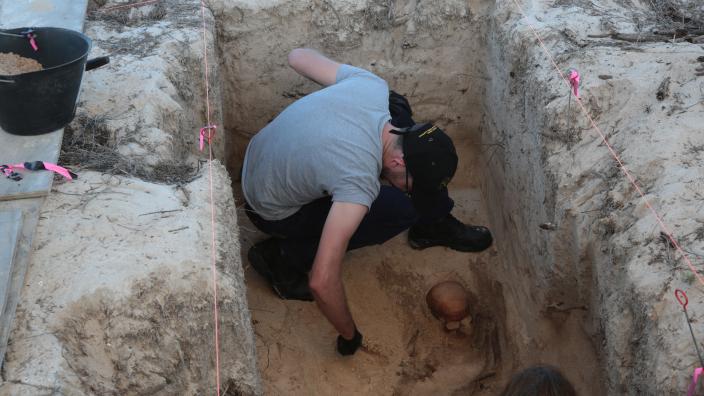 Archaeologist carefully excavating new burial site at Beacon Island.