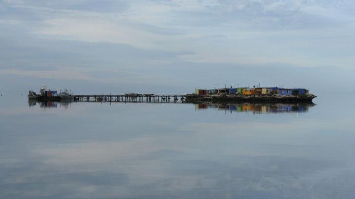 A reflection of a pier on the calm waters