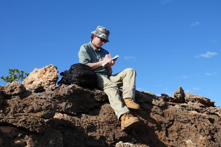 A person sitting on a rocky outcrop