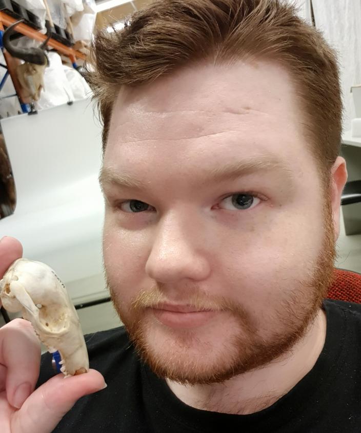 Jake Newman-Martin holding a skull of a bettong