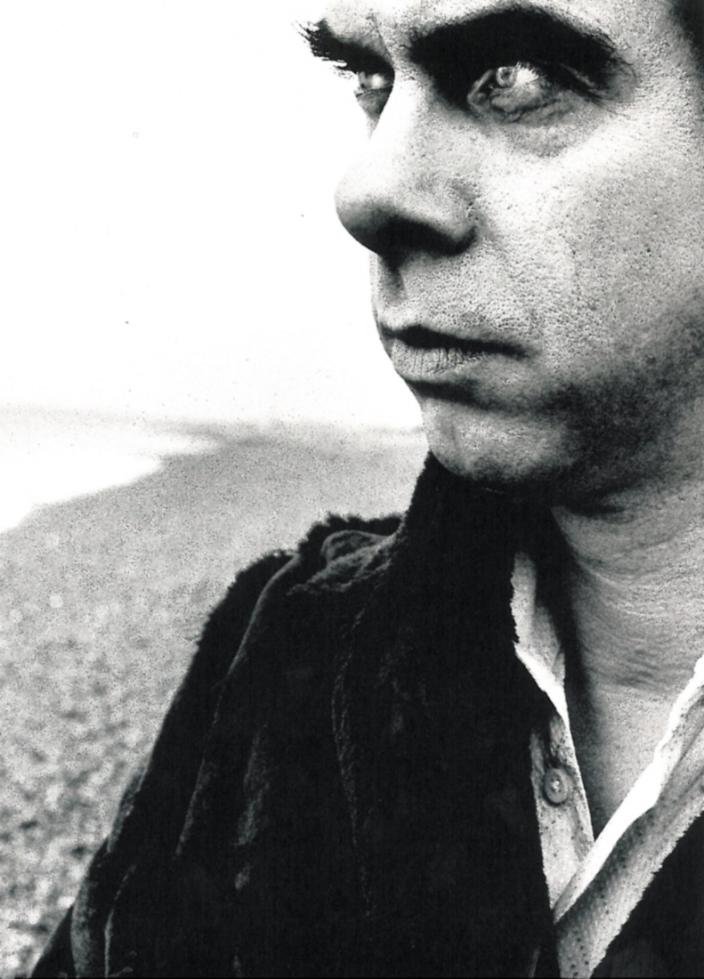 Close up Nick Cave with intense on Hove, UK beach with stones in the background