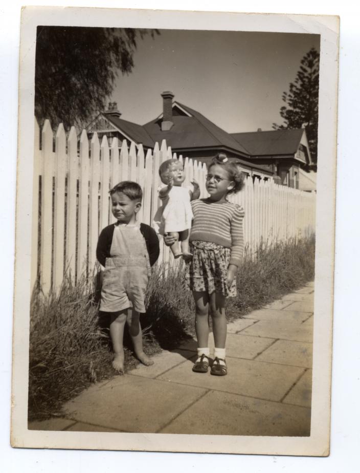 Nonja with her doll and brother standing on a Subiaco street