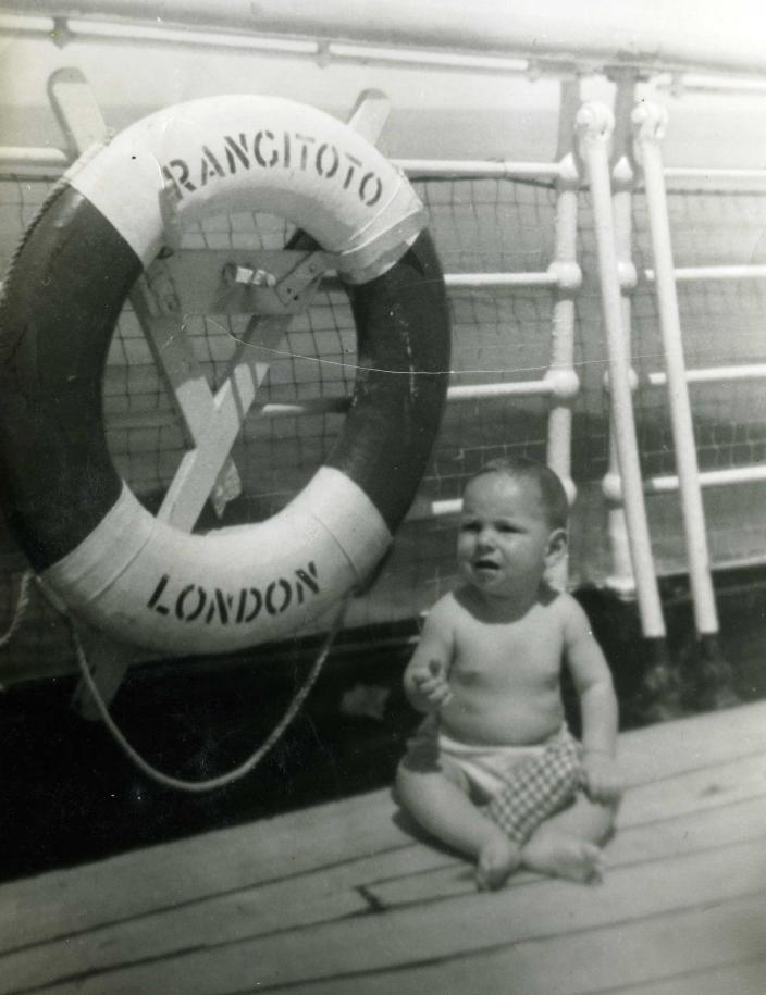 A baby Stephen Anstey sitting on a ship deck