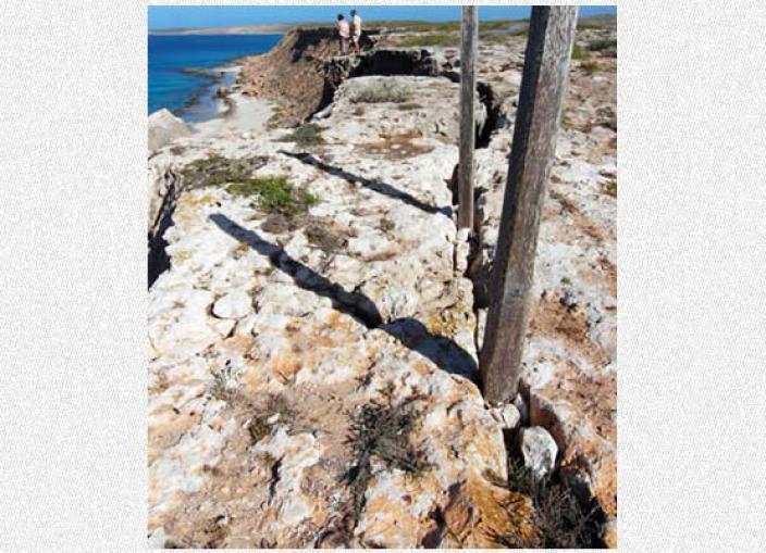 View of a commerative post near the shoreline on an island