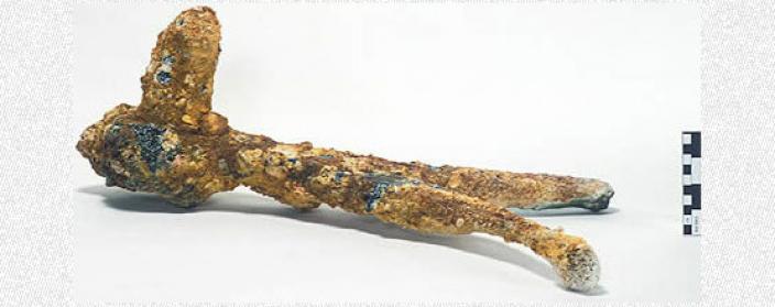A copper alloy object covered in corrision