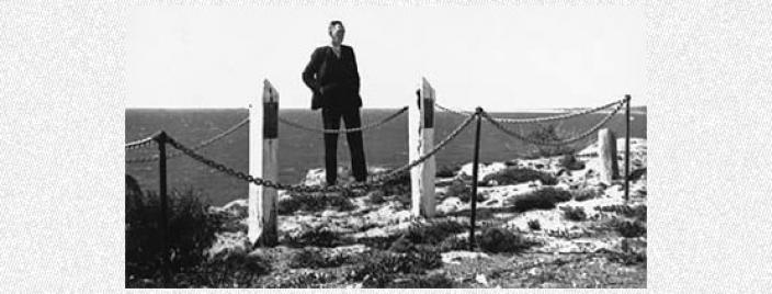 Man standing next to memorial posts