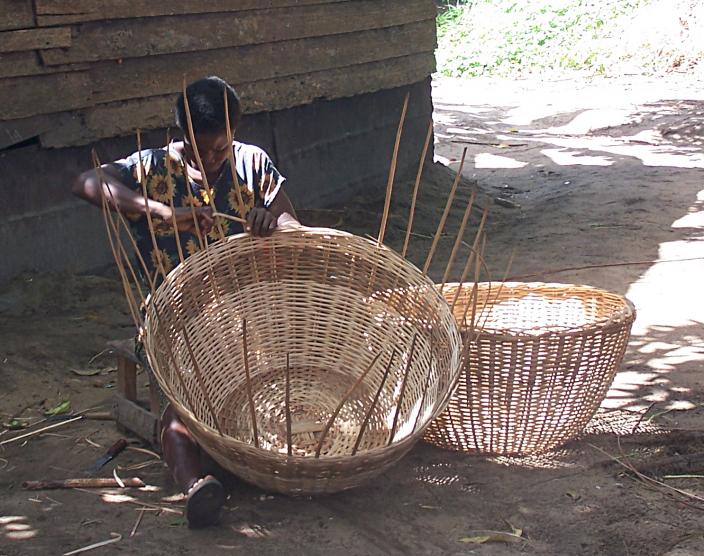 A woman weaving baskets near Lake Ossa